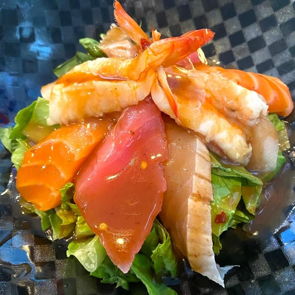 Sushi 4 Reel's vibrant sashimi salad with shrimp, tuna, and salmon on fresh greens.