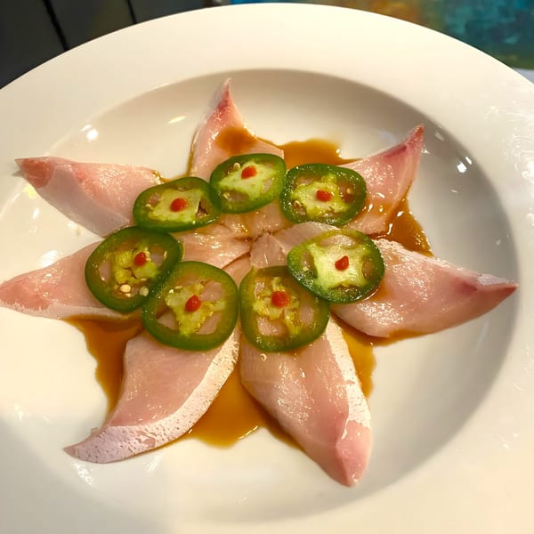 Sushi 4 Reel's Hamachi Carpaccio, thinly sliced yellowtail sashimi arranged in a star shape with jalapeños.